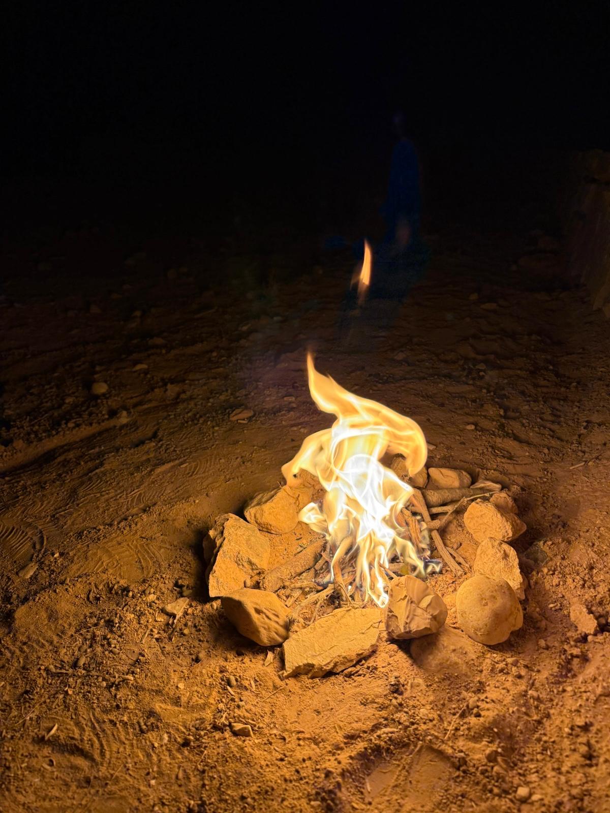 A small campfire in the desert at night
